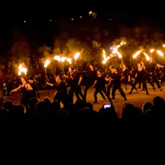 Ett eldshow med många facklor under Uppsala kultur natt. En publik ser på när artister dansar med elden.