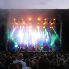 Stor publik njuter av en konsert i Botaniska trädgården. Scenen badar i ljus och rök.