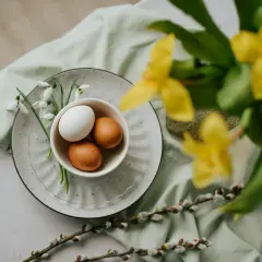 Påsk i Sverige: ägg i en skål med snödroppar, videkissar och gula blommor.