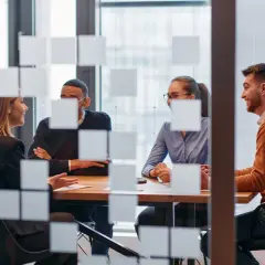 Key account manager diskuterar med kollegor vid ett mötesbord.
