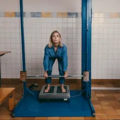 Kvinna gör sig redo för ett styrketest, kanske för att se om hon klarar "kan jag bli polis test". Hon håller i en skivstång.
