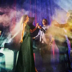 Scen från gbg operan med sångare och pianist i rökig, dramatisk belysning.