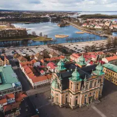 Vacker vy över Kalmar med domkyrkan i förgrunden. Vatten, broar och stadens tak ger en känsla av många aktiviteter kalmar.