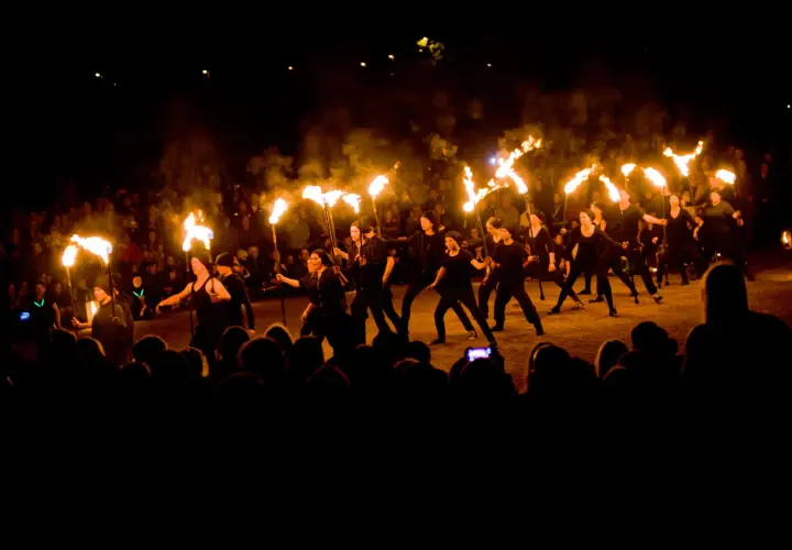 Ett eldshow med många facklor under Uppsala kultur natt. En publik ser på när artister dansar med elden.