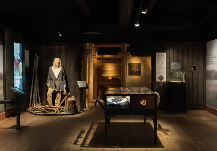 I en vikingamuseum står en vaxdocka som en viking. Utställningen visar föremål och information om vikingatiden.