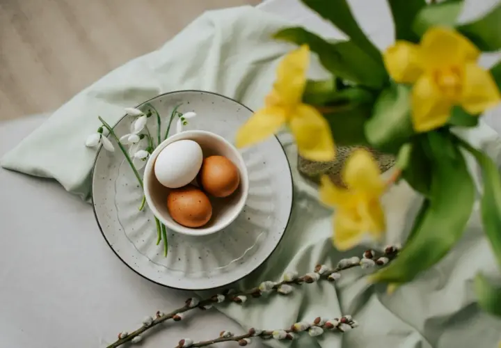 Påsk i Sverige: ägg i en skål med snödroppar, videkissar och gula blommor.