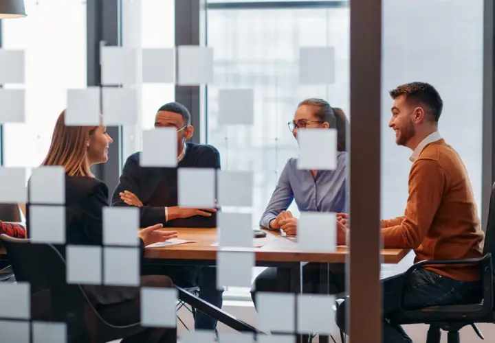 Key account manager diskuterar med kollegor vid ett mötesbord.