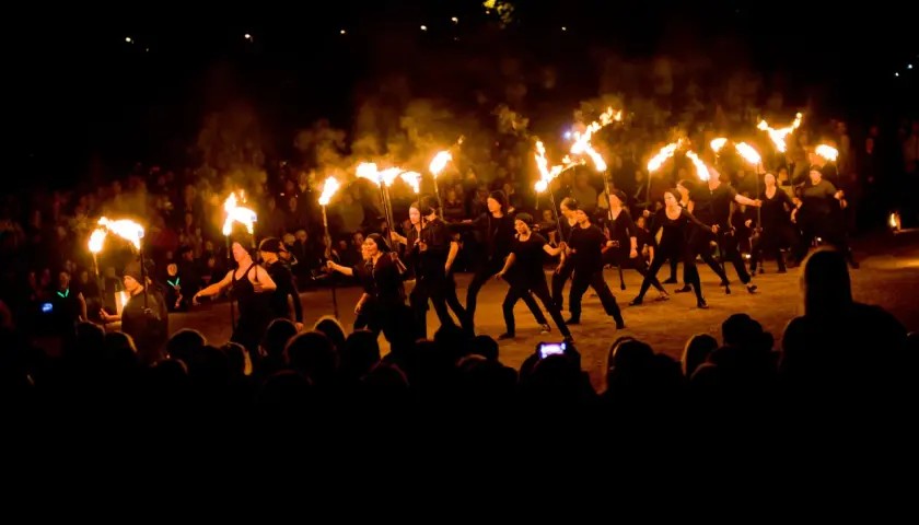 Ett eldshow med många facklor under Uppsala kultur natt. En publik ser på när artister dansar med elden.