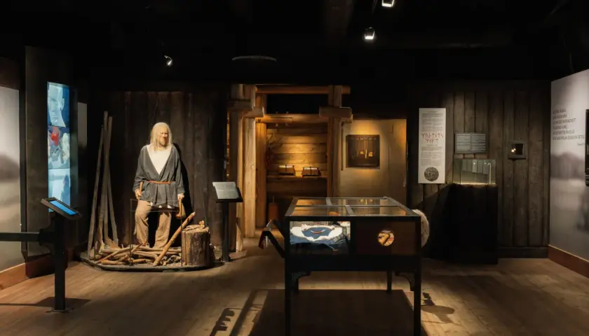 I en vikingamuseum står en vaxdocka som en viking. Utställningen visar föremål och information om vikingatiden.