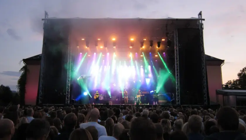 Stor publik njuter av en konsert i Botaniska trädgården. Scenen badar i ljus och rök.