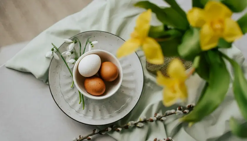 Påsk i Sverige: ägg i en skål med snödroppar, videkissar och gula blommor.