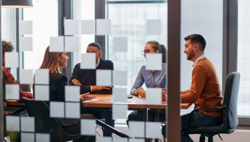 Key account manager diskuterar med kollegor vid ett mötesbord.