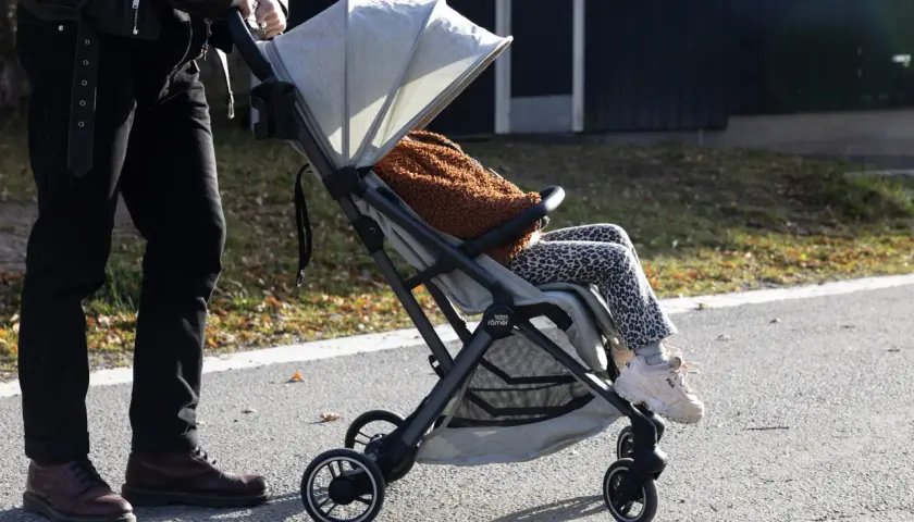En person med barn i barnvagn njuter av utomhusaktiviteter i Stockholm.