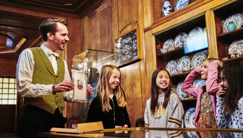 En guide visar ett porträtt för barn på Hallwylska museet.