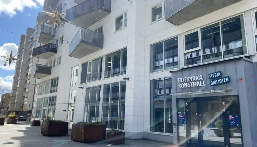 Modern byggnad med balkonger och stora fönster. Skylten "BOTKYRKA KONSTHALL" syns tydligt.