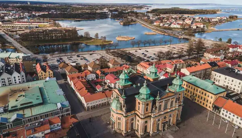 Vacker vy över Kalmar med domkyrkan i förgrunden. Vatten, broar och stadens tak ger en känsla av många aktiviteter kalmar.