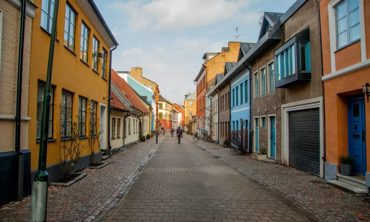 En kullerstensgata i Skåne med färgglada hus. Perfekt för gratis aktiviteter som en promenad eller cykeltur.