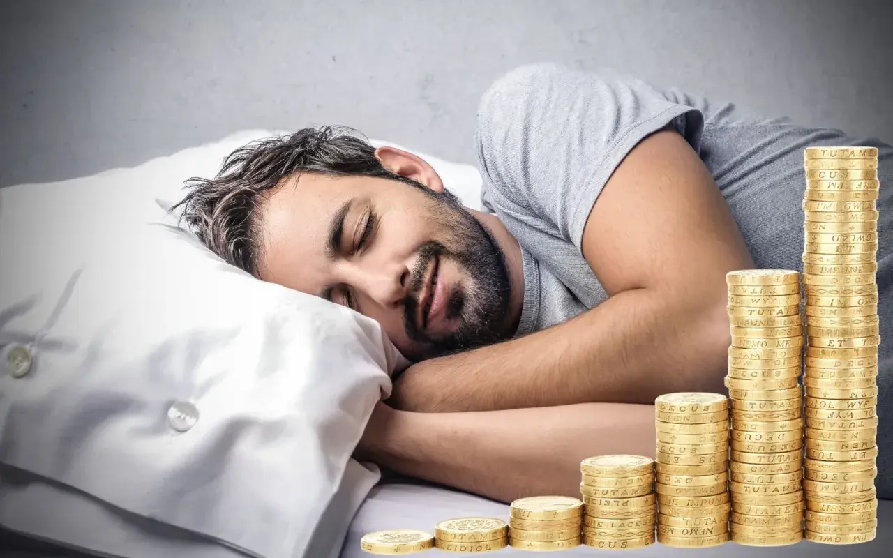 Man sover lugnt bredvid en växande stapel mynt, en dröm om passiva inkomster som blir verklighet.