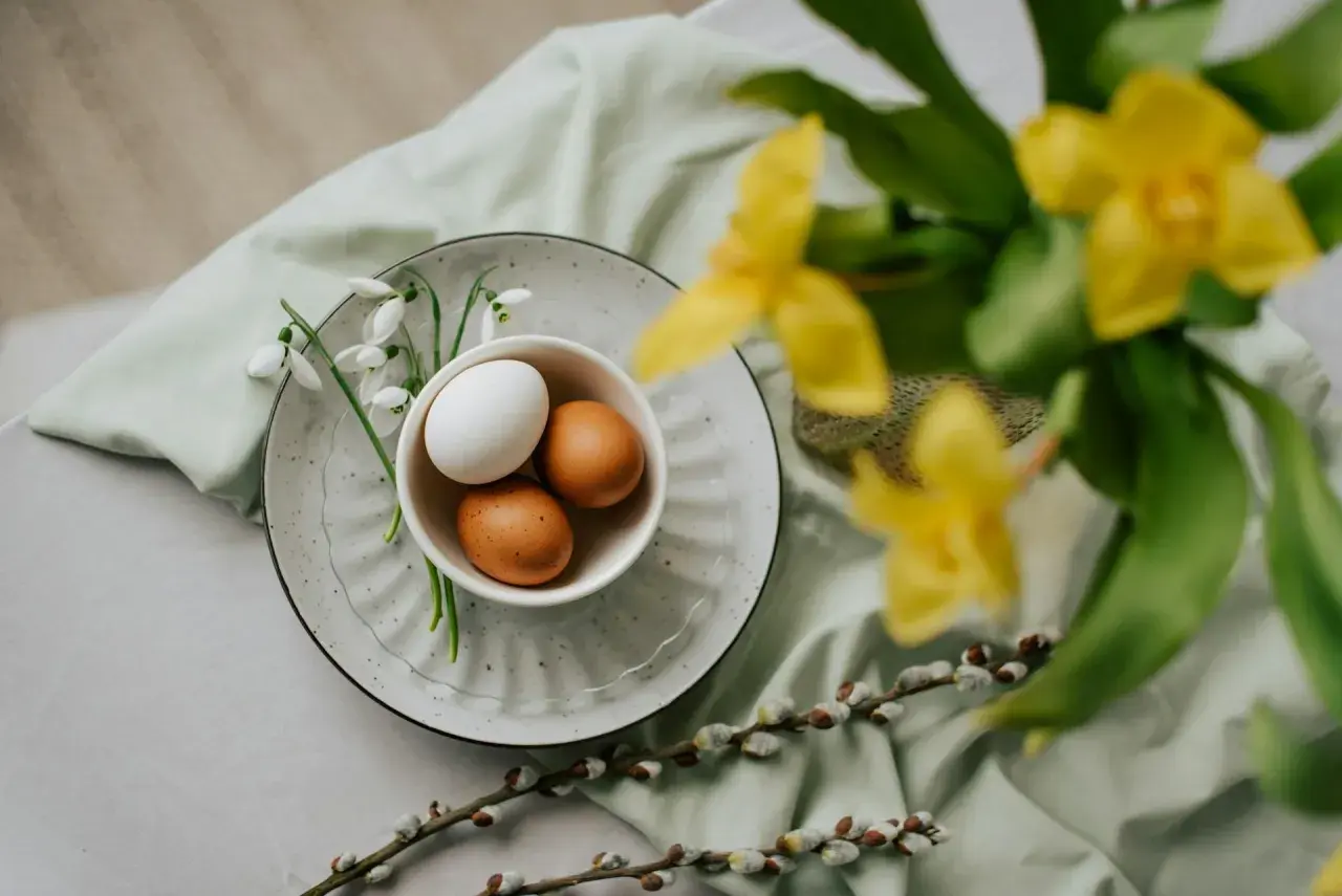 Påsk i Sverige: ägg i en skål med snödroppar, videkissar och gula blommor.