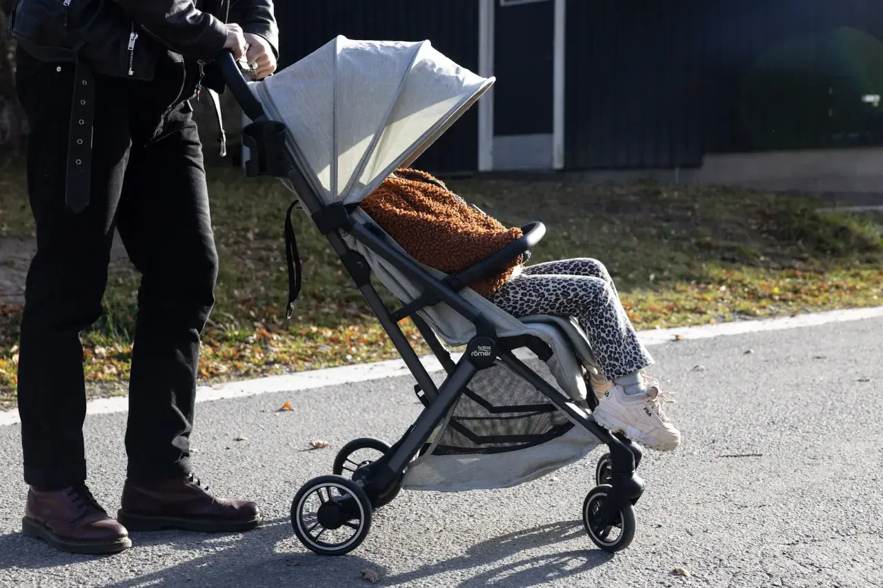 En person med barn i barnvagn njuter av utomhusaktiviteter i Stockholm.