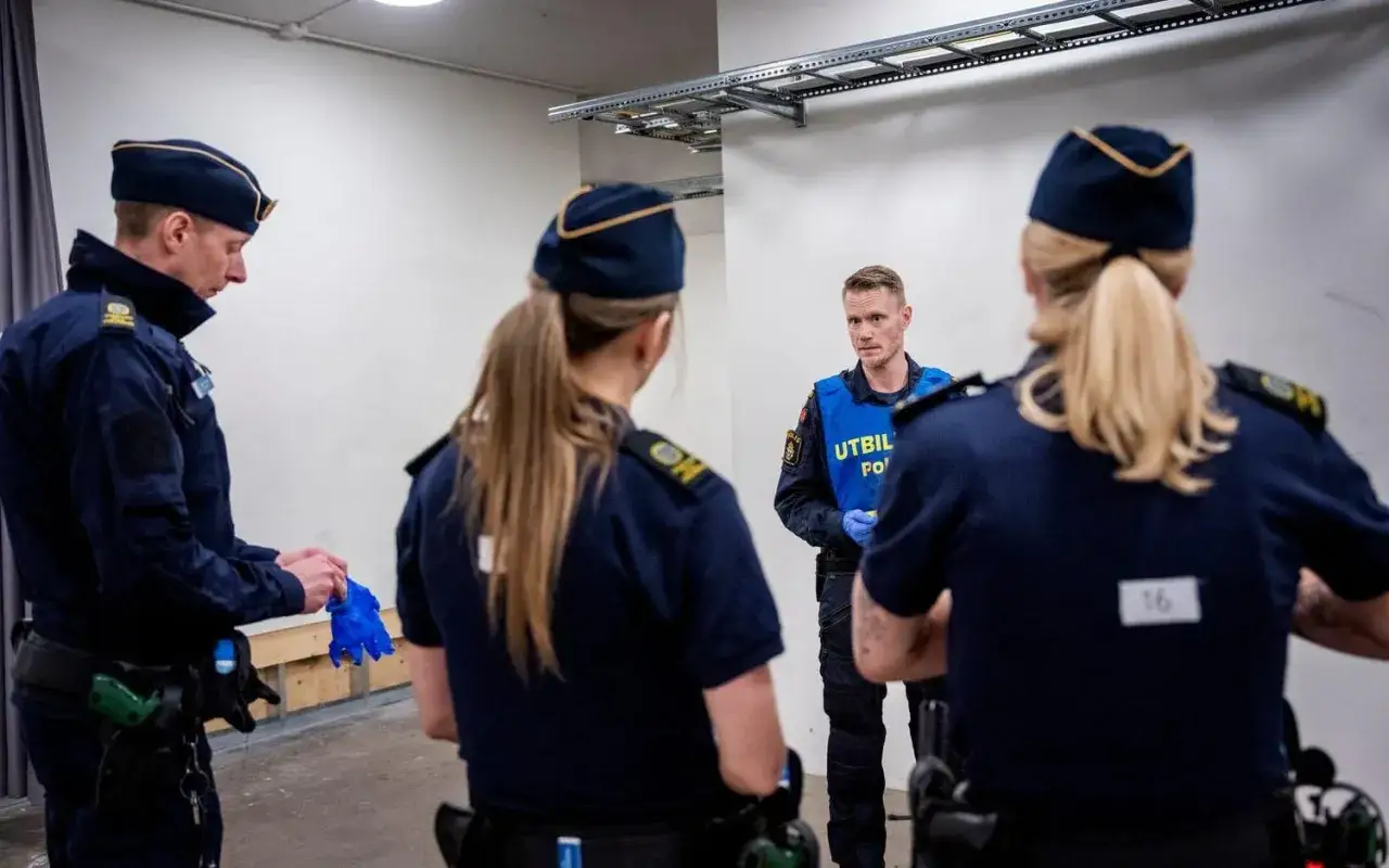 Poliser i blå uniformer och mössor, en med texten