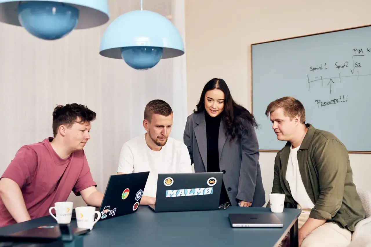 Teamet diskuterar strategier, d&auml;r en key account manager leder m&ouml;tet framf&ouml;r en whiteboard med anteckningar.