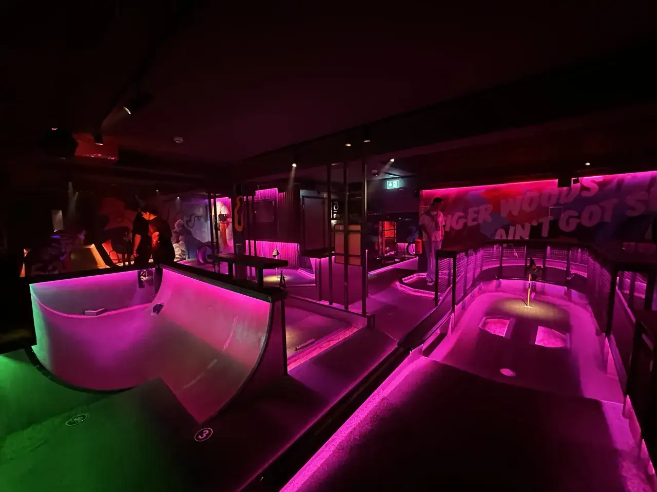 En neonupplyst minigolfbana i Göteborg med en ramp och en flagga.