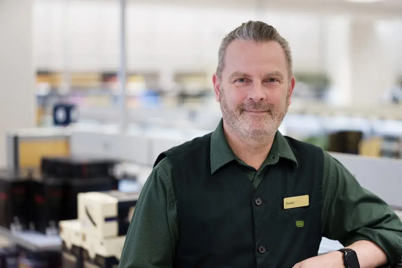Henke, en v&auml;nlig sem specialist, ler mot kameran i en butiksmilj&ouml;.